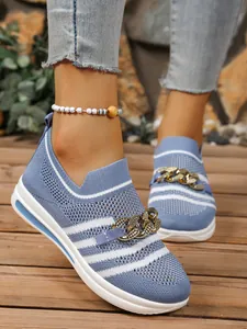 Detail of blue knit sneakers with gold chain ornament and breathable mesh upper