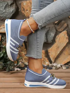 Close-up of blue knitted mesh loafers with stylish gold chain detail on wedge sole