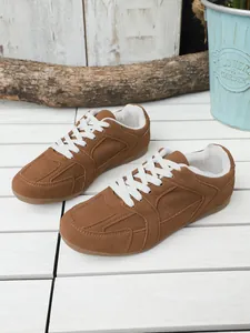 Vista detallada de zapatillas retro marrones de estilo militar con cordones blancos y suela