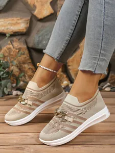 Close-up of flyknit casual sneakers with elegant metal chain buckle and thick white sole