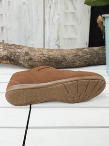 Vista detallada de zapatilla retro de ante marrón con suela de goma antideslizante