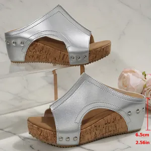 Vue détaillée de mules compensées argentées avec clous stylés et talon de 6,5 cm