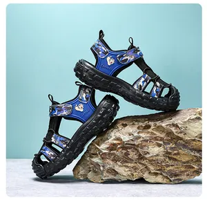 Vue détaillée de sandales camouflage bleues pour garçons sur un rocher naturel.