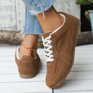 Retro bruine suède sneakers voor dames met witte veters en een platte rubberen zool