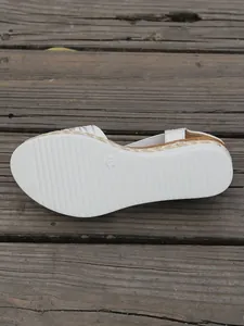 Close-up detail showing the white grooved non-slip sole of the espadrille wedge sandal.