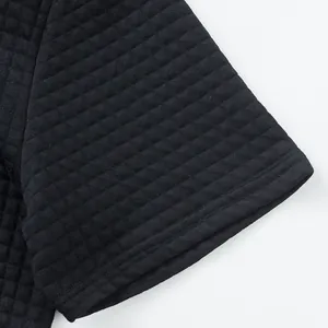 Close-up of heavyweight jacquard fabric on black short sleeve polo shirt sleeve