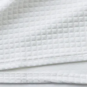 Close-up of white heavy jacquard waffle knit fabric with small square pattern detail