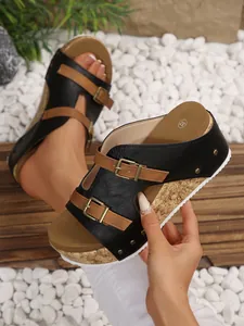 Detailed view of women's platform wedge sandals with buckle straps and cork texture