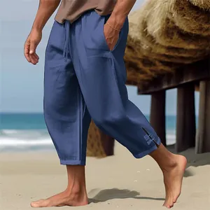 Detalle de la abertura lateral y textura de lino de los pantalones de playa azules