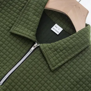 Close-up of army green jacquard textured polo shirt with zipper detail and collar