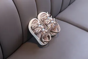 Detailed view of elegant girls' princess sandals in rose gold with bow and rhinestones
