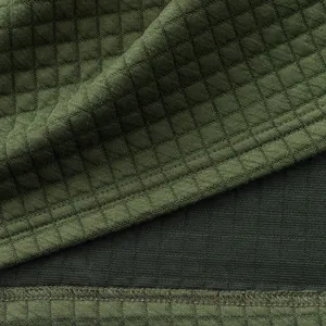 Close-up of heavyweight green jacquard fabric with a small square grid pattern.