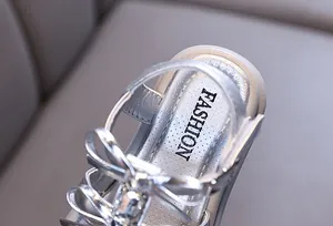 Close-up of silver girl's princess sandals with rhinestone bow and fashion insole