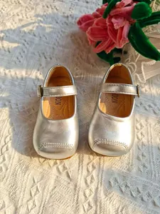 Detailansicht von oben auf süße silberne Metallic-Mary-Jane-Prinzessin-Schuhe