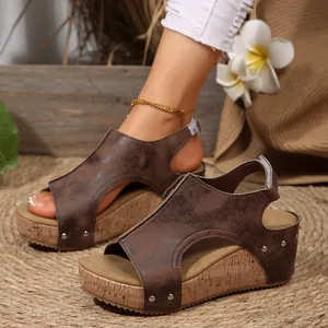 Close-up of vintage brown wedge sandals featuring rivets and a cork-style platform sole.