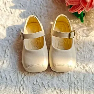 Nahaufnahme von cremefarbenen Mary Jane Prinzessinnenschuhen für Mädchen mit Metallschnalle