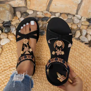 Detailansicht schwarzer Boho-Sandalen mit Blumendekoration und elastischem Riemen.