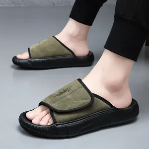 Close-up of men's green suede slides with thick black soles and embroidered detail.
