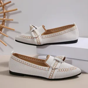 Dettaglio di ballerine a punta in maglia bianca con fiocco e motivo a catena decorativo
