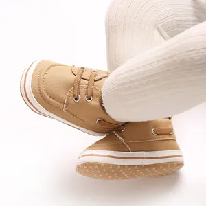 Detail shot of brown canvas baby walking shoes on infant feet with white soles
