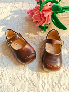 Elegante braune Mary Jane Lederschuhe für Mädchen mit süßem floralem Hintergrund.