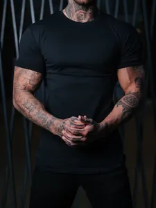 Close-up of men's athletic slim fit black T-shirt showing muscle fit and elastic fabric