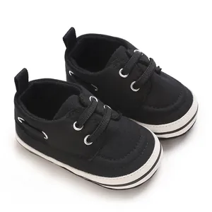 Close-up detail of black canvas infant walker shoes with white rubber soles