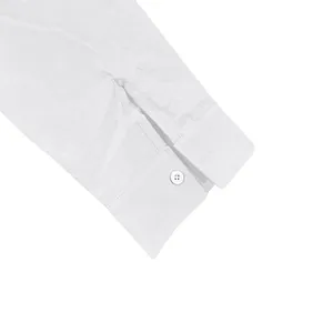 Close-up detail of a white linen long sleeve shirt cuff featuring a single button closure