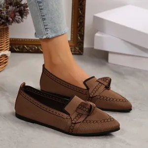 Dettaglio di scarpe basse marroni in maglia a punta con decorazione a fiocco elegante