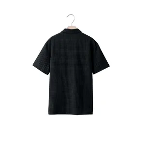 Back view of men's black jacquard waffle knit short sleeve polo shirt with texture.