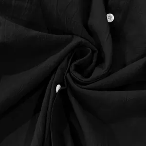 Macro view of black linen fabric texture and white buttons of a men's casual shirt