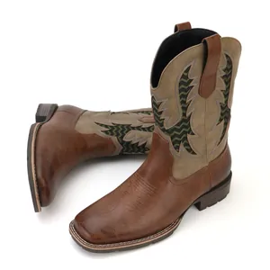 Close-up detail of vintage embroidered patterns on brown western cowboy boots for men.