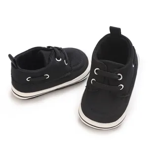 Detail view of black canvas baby toddler shoes with white non-slip rubber soles
