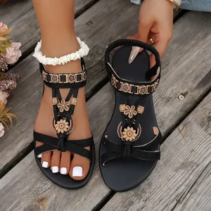Detailed view of Bohemian black flat sandals with floral embellishments and elastic strap