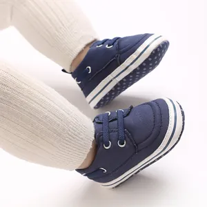 Close-up view of navy blue canvas baby walking shoes featuring a white polka dot sole