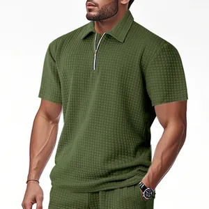 Close-up view of olive green waffle knit men's polo shirt with functional zipper detail.