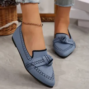Dettaglio di scarpe basse in maglia azzurra con punta e fiocco decorativo