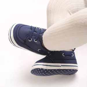 Close-up of navy canvas baby walking shoes with white polka dot anti-slip sole.