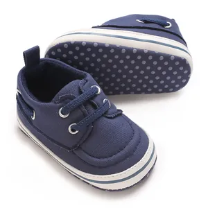 Detail view of navy blue canvas baby pre-walker shoes with polka dot non-slip sole.