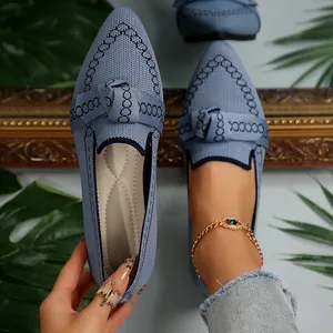 Dettaglio ballerine blu a punta con fiocco, rete traspirante e motivo a catena.