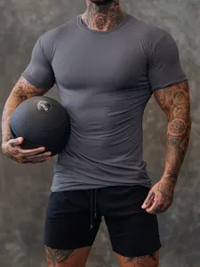 Tight-fitting grey men's fitness compression t-shirt highlighting muscle definition
