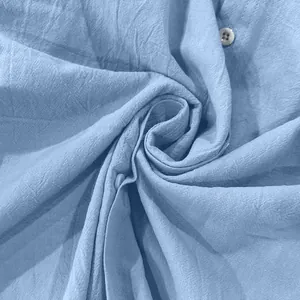 Macro detail of breathable light blue linen fabric texture with a classic button