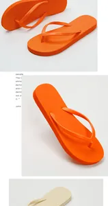 Close-up of bright orange flip-flops with anti-slip textured soles for summer beach wear.