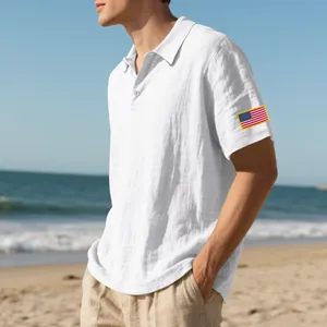 Detail van de geborduurde Amerikaanse vlag op de mouw van een wit linnen poloshirt voor heren