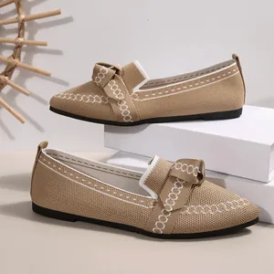 Dettaglio di ballerine a punta in maglia traspirante con fiocco decorativo da donna.