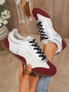 Detailed view of women's color-blocked sneakers with maroon and silver metallic accents