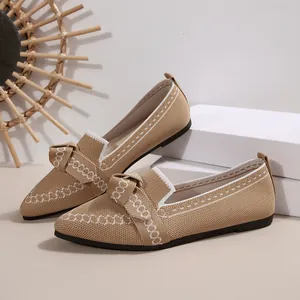 Dettaglio di ballerine a punta in maglia traspirante con fiocco e ricamo bianco elegante