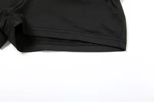 Gros plan sur les coutures durables et la texture du tissu du short noir taille haute.