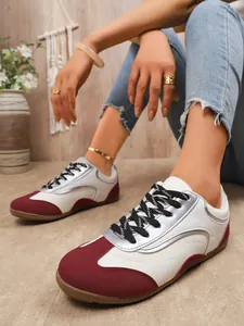 Detailed view of women's color-blocked GAT sneakers in burgundy and white with silver accents