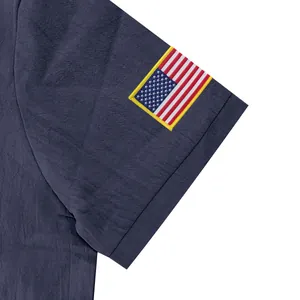 Detail van het Amerikaanse vlagborduurwerk op de mouw van een donkerblauwe linnen polo